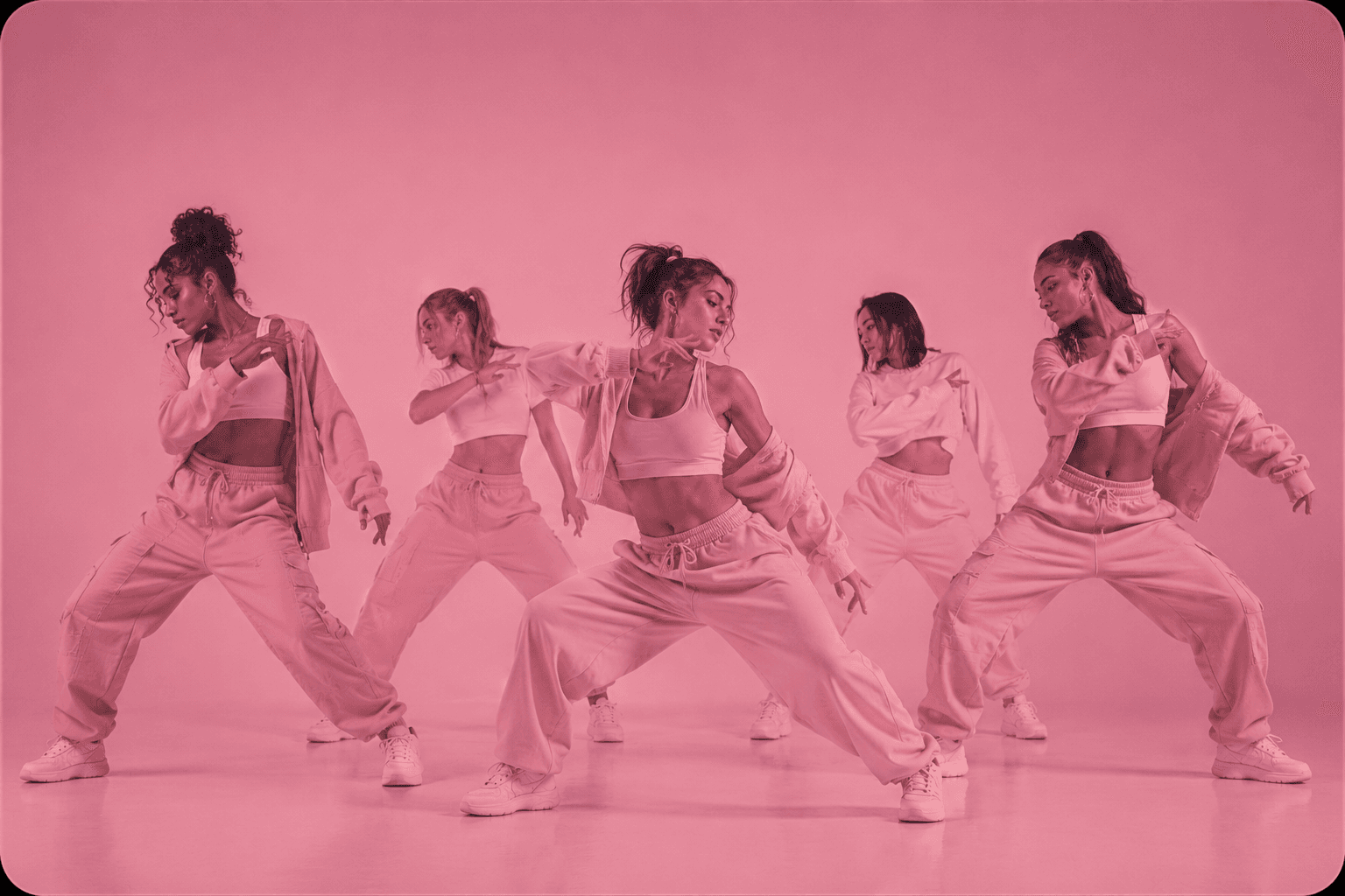 Groupe de danseuses en pleine chorégraphie sur un fond rose